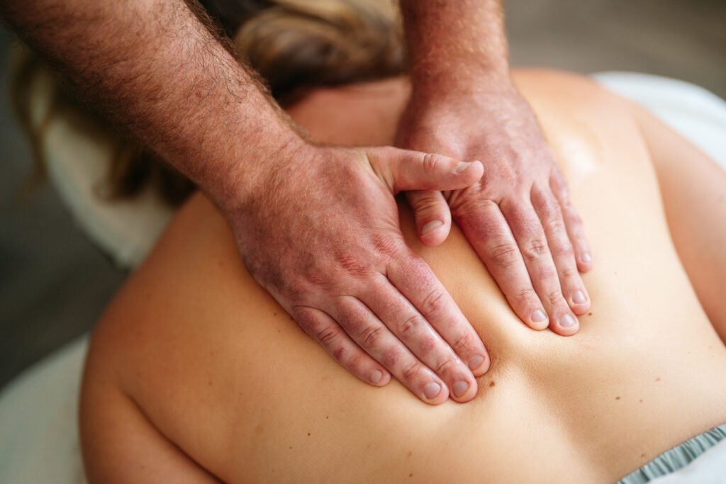 Two hands on back. Massage Therapist effleurage